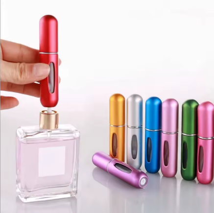 Pocket perfume atomizer beside a perfume bottle